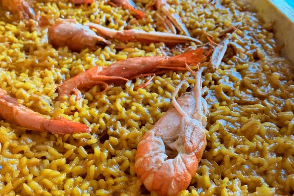 Paella valenciana tradicional recién hecha en la paellera